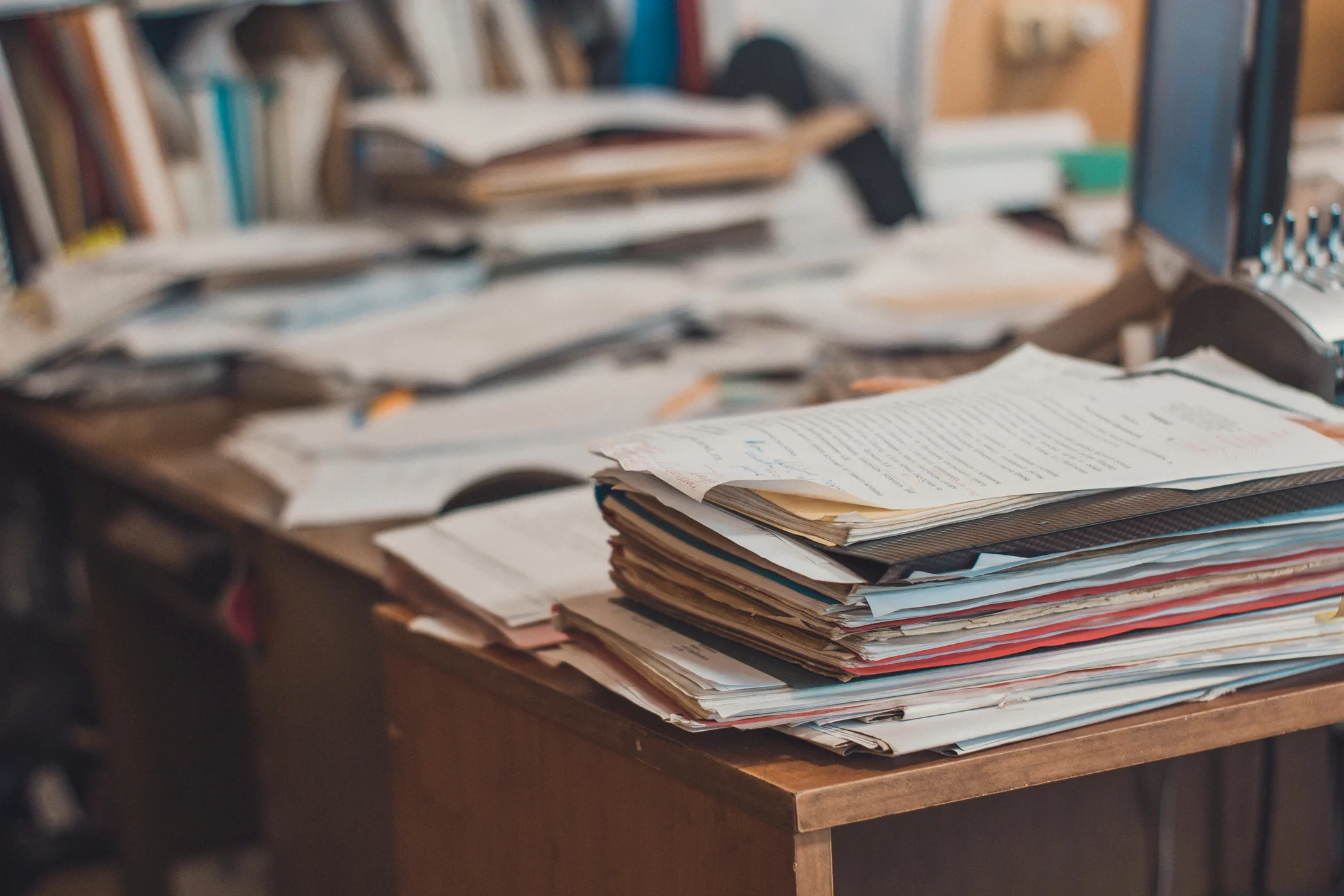 Stacked folders and papers on a desk