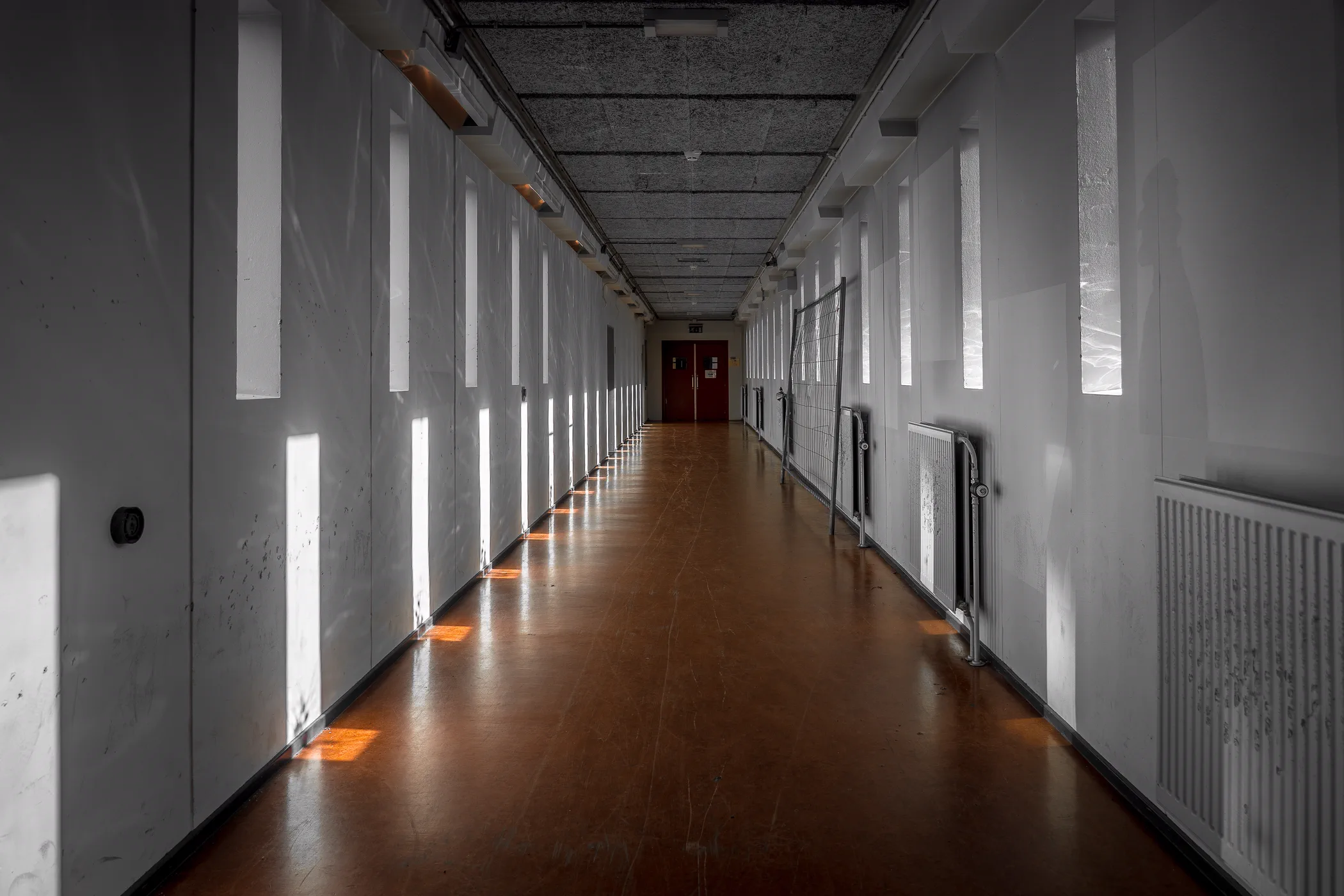 A long empty corridor lit from the windows along one side